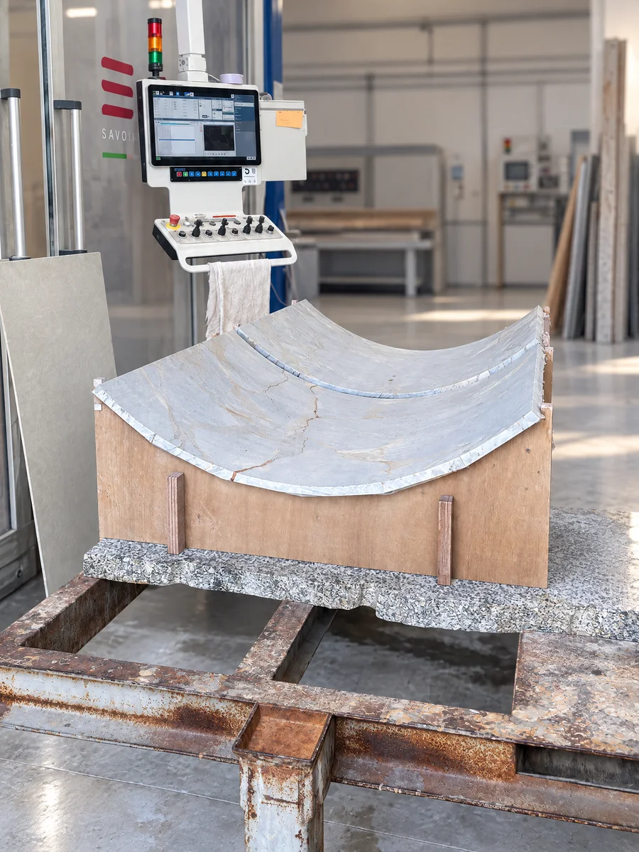 Lastra di marmo curvata appoggiata sulla dima di legno, officina Savoia Marmi