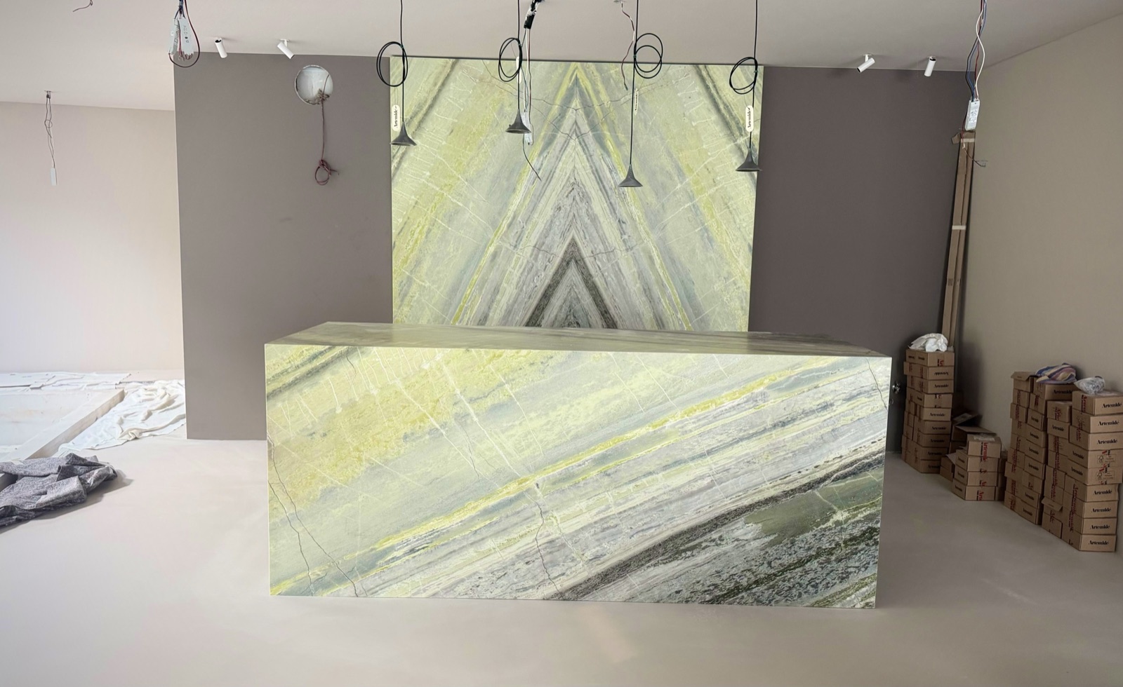 La hall dell'hotel a luce spenta: parete a macchia aperta e bancone in Irish Green