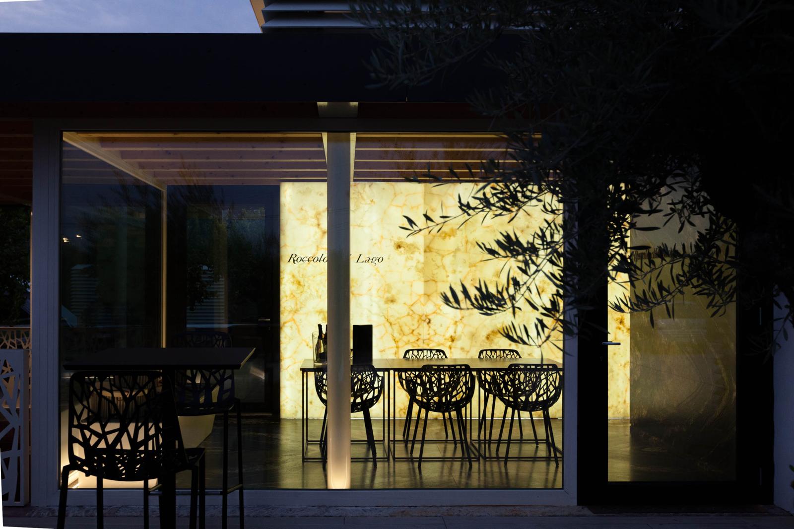 Parete retroilluminata in pietra al crepuscolo, sala degustazione Cantina Roccolo del Lago